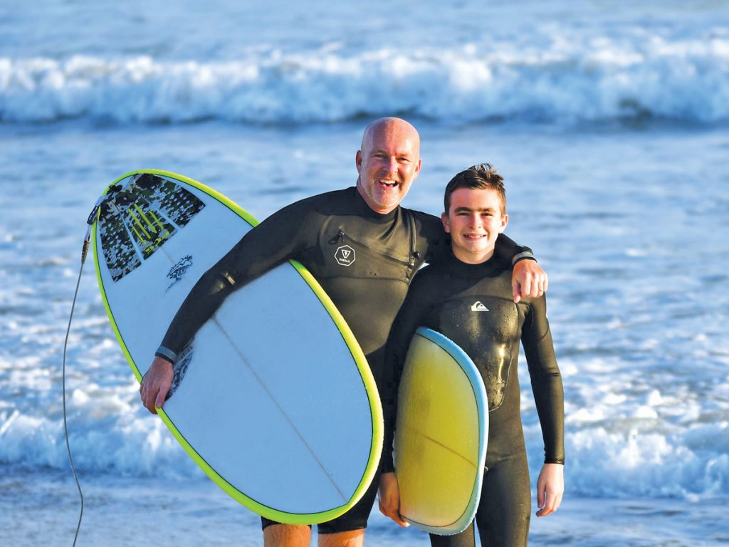 Tripp Hernandez and his son Noah enjoy a surf day at the Fort Pierce Inlet. Photo by Bill Davis