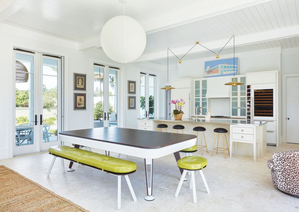 The kitchen combines old and new treasures, including four Georg Baselitz prints from the 1960s and a dining table that doubles as a pool table. Photography by Brantley Photo
