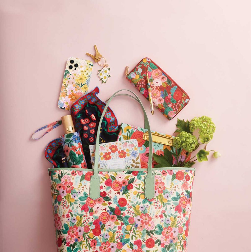 This Rifle tote bag overflows with other colorful Rifle items, like wallet, key chain, pen, umbrella, silk scarf, phone cover, notebook, and “clipfolio.”
