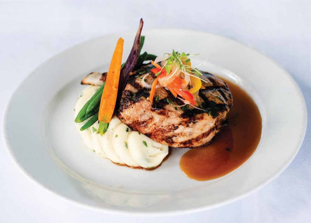 Brined, grilled pork chops at The Tides. Photography by Kim Bottalico