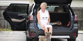 Leigh Bergstrom prepares for her Tuesday routes, accompanied by Pepper, her potcake dog, rescued from The Bahamas. Photo by Steven Martine
