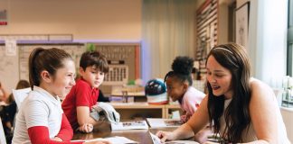 Madalyn works with third grade teacher Noelle Grantham during a reading period that includes a section on space. Anthony and Zuri look on. Photography by Kim Bottalico