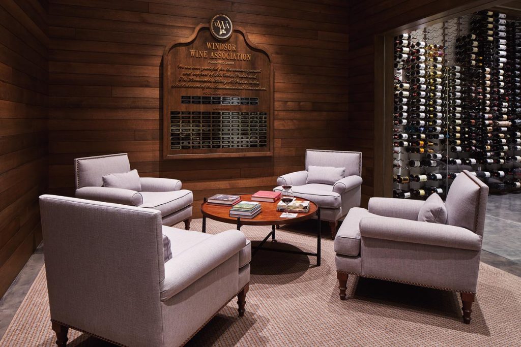 A sitting area boasts a view of the wine cellar behind a wall of glass. Photo by Aric Attas