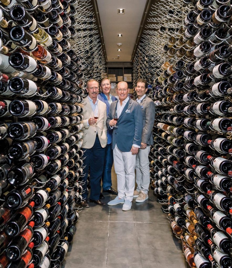Windsor residents Rob Long, Bob King, Jeff Zimmer, and Jon Rubinstein stand in the wine cellar established by the Weston family. Photo by Verola Media