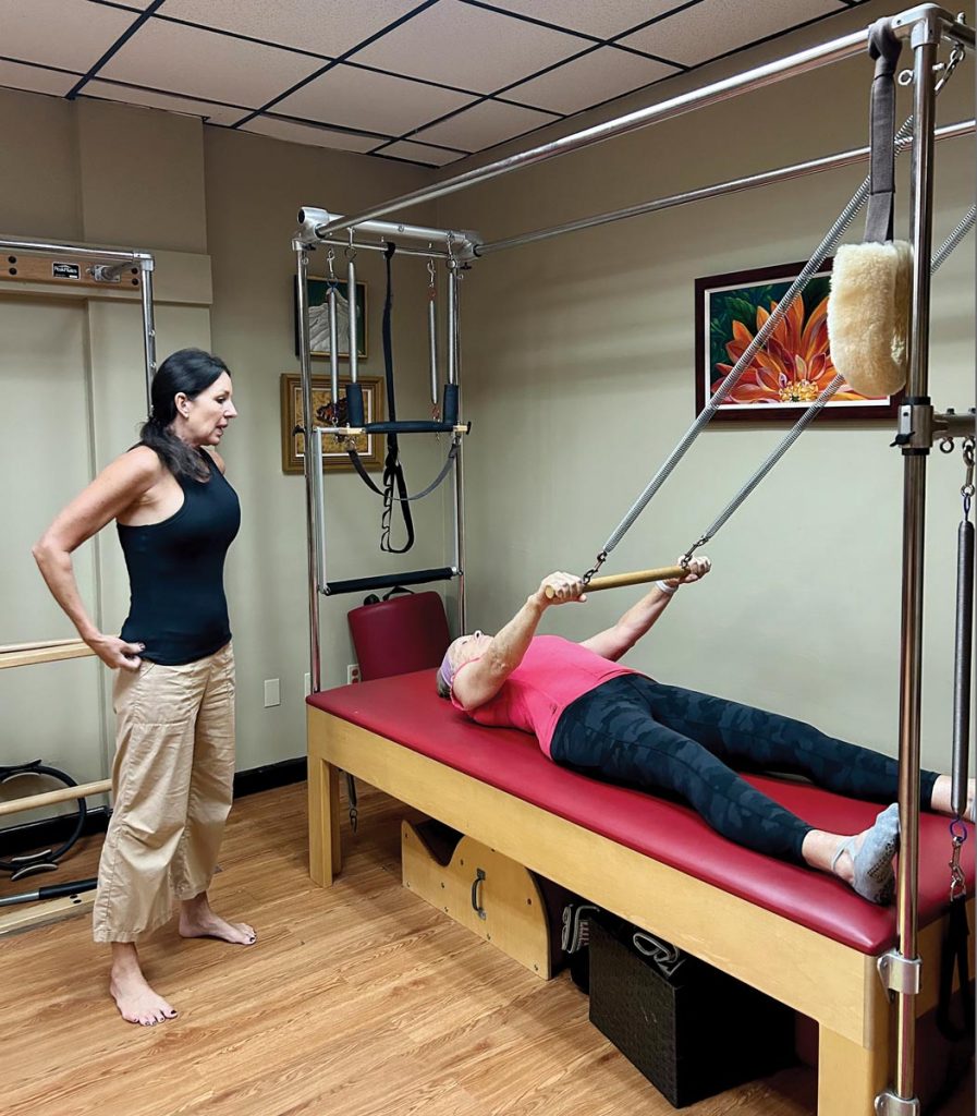 Mary Sloan works out on the Pilates Cadillac under the watchful eye of Taunya Foerster, owner of Vero Beach Pilates