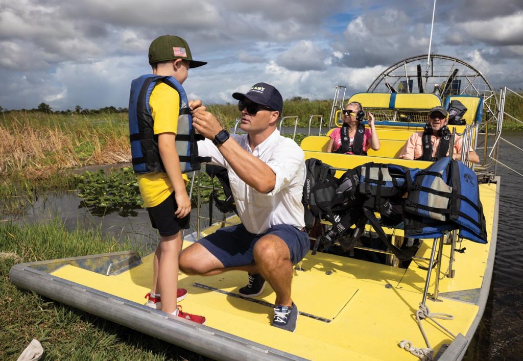 John Calhoun helps Reece into a life jacket before launching. Photo by Sam Wolfe