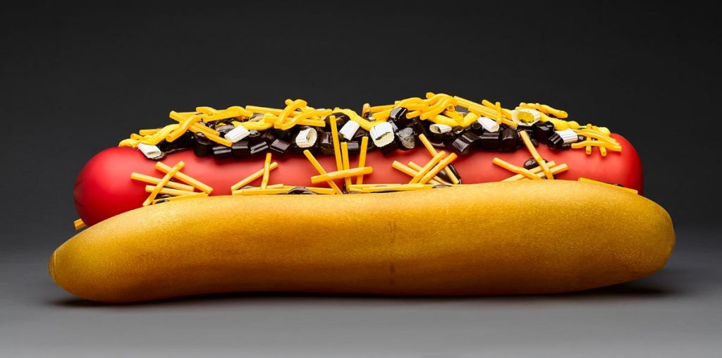 Chili Dog by John Miller ( 2024). Blown and hot sculpted glass, 32 x 10 x 11 inches. Photo by Aric Attas © John Miller