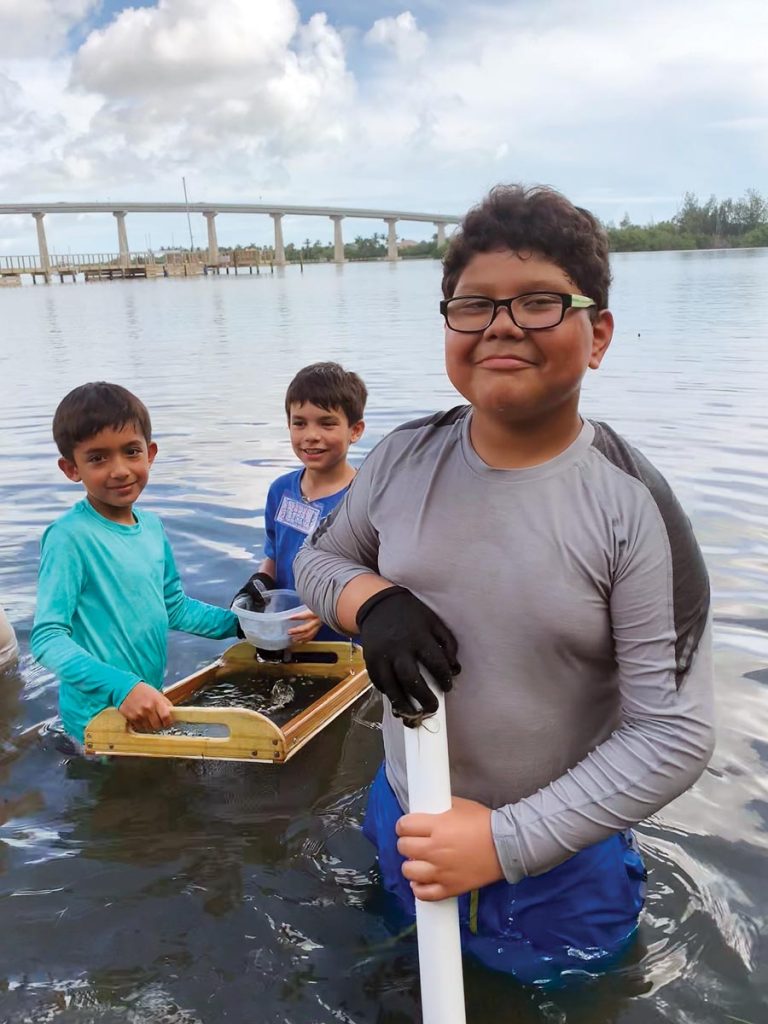 Students collecting and studying specimens from the lagoon. Photo by Heather Kramer