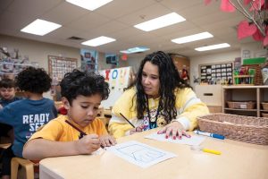 Martinez sits with her son Julian in his classroom. Photo by Steven Martine