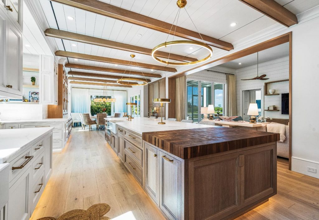 Stained oak cabinetry in the kitchen and Ralph Lauren lighting above the island flow together seamlessly. Photo by M. James Northen