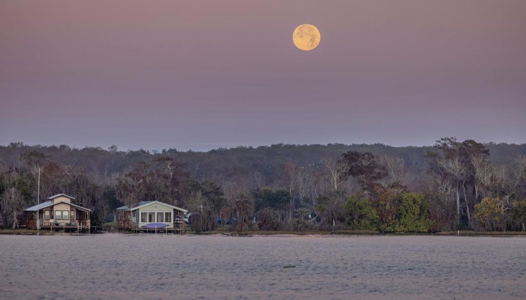 A full moon sets over the small fishing village on the western edge of the lake. Photo by Sam Wolfe