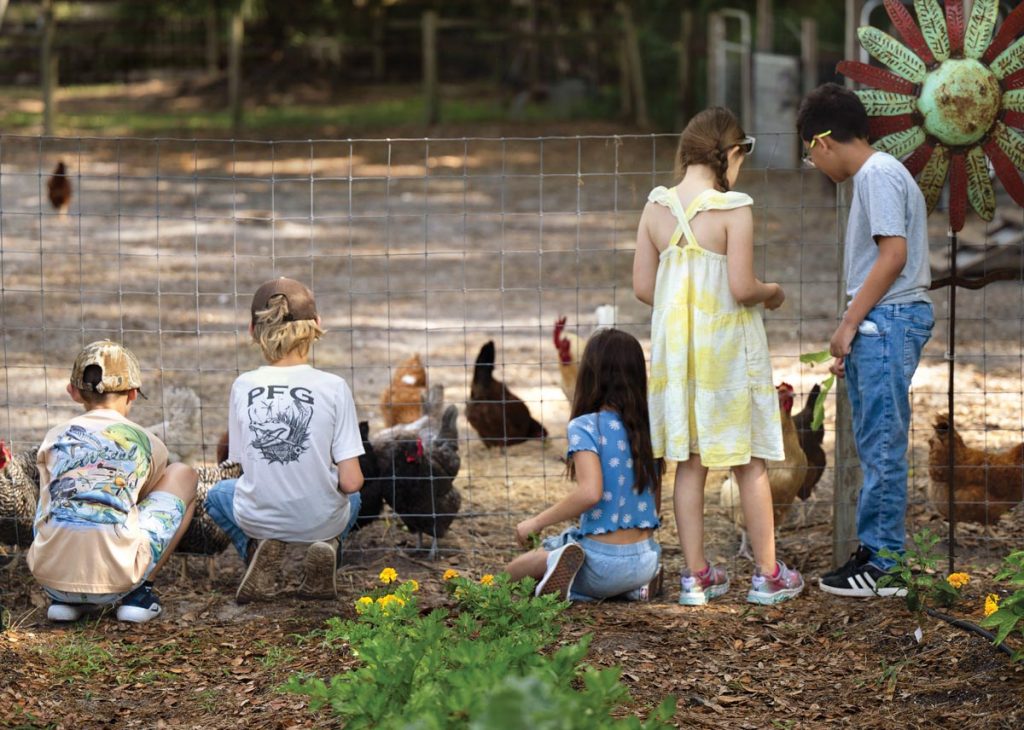 “Even weeding is fun because we get to feed the weeds to the chickens.” — Evie Sarbak. Photo by Steven Martine