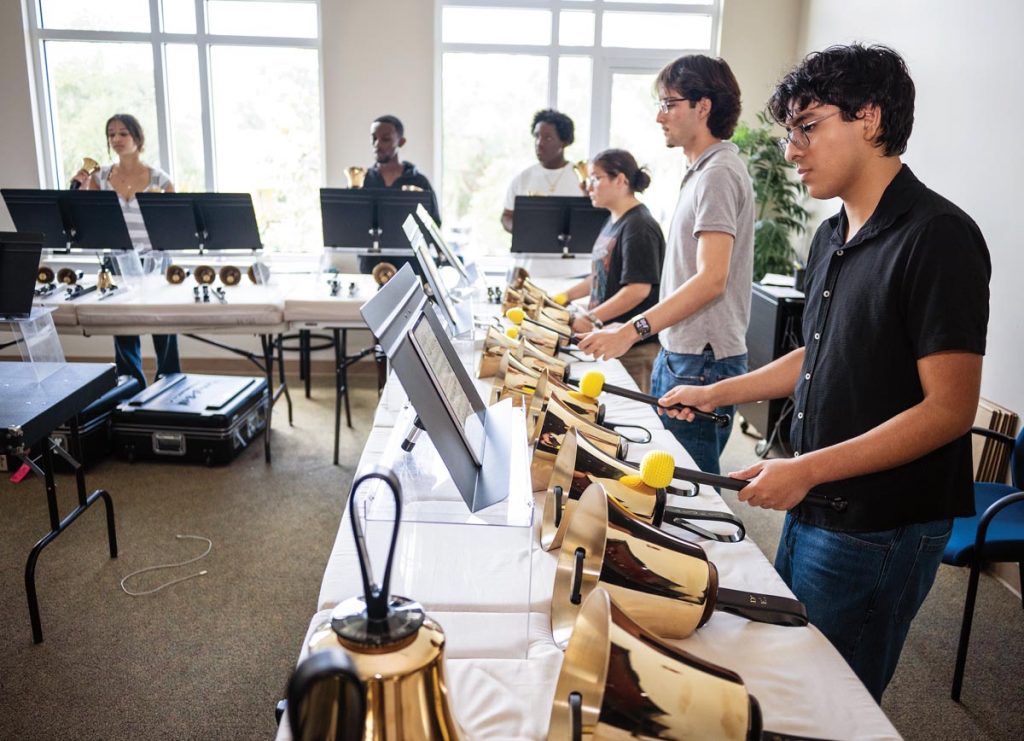 Handbell choir is all about teamwork, whether hitting the right note in a melodic phrase or carrying 40-pound bell cases to performances. Photo by Steven Martine