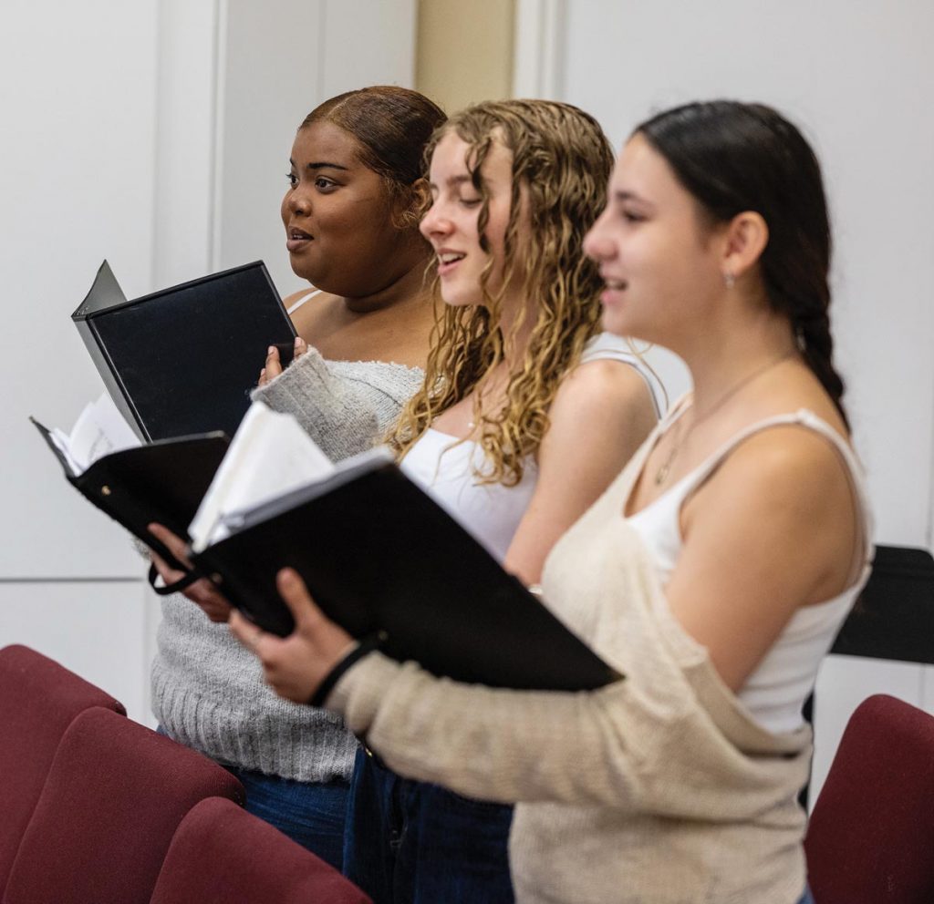 Sopranos Lanaya King, Arya Padnuk, and Paula Malave-Medina hit a joyful note at a recent practice. Photo by Steven Martine